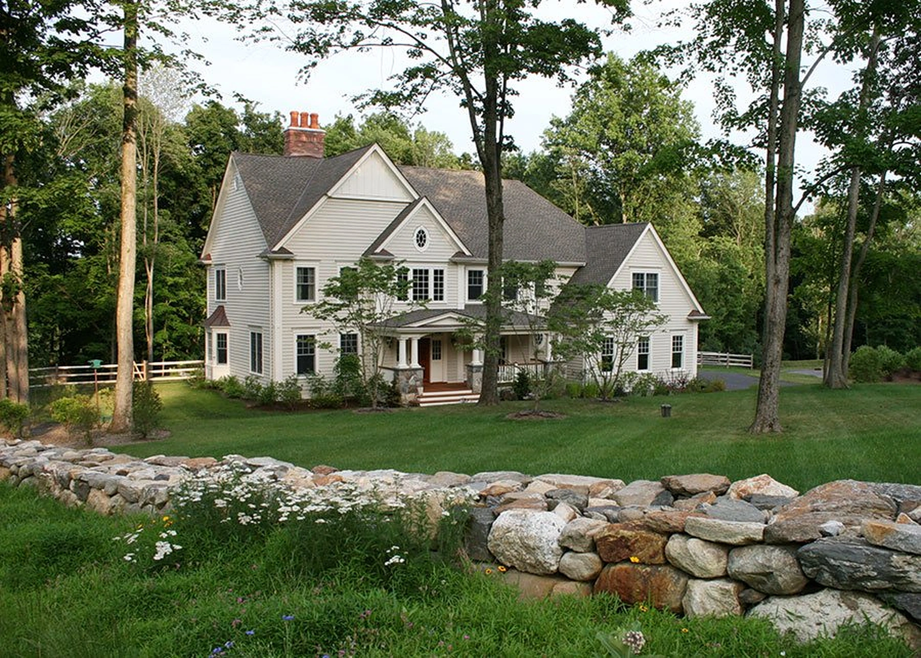 Traditional Ridgeview home set among mature trees and a stone wall